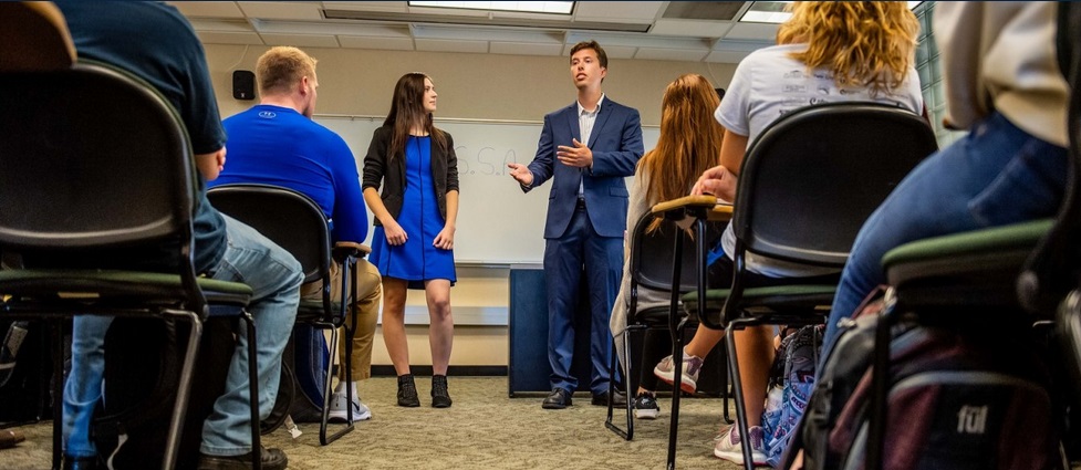 Two students presenting at the front of a class